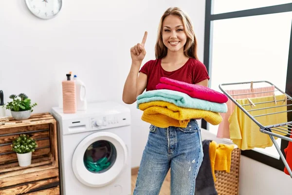 Young Caucasian Woman Holding Clean Laundry Smiling Idea Question Pointing — Stock Photo, Image