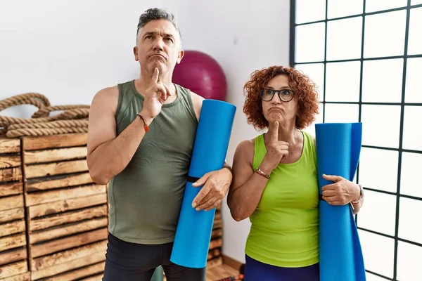 Pareja Mediana Edad Sosteniendo Esterilla Yoga Pensando Concentrada Duda Con — Foto de Stock