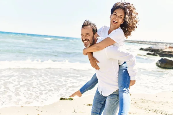 Homem Hispânico Meia Idade Sorrindo Feliz Segurando Mulher Costas Praia — Fotografia de Stock
