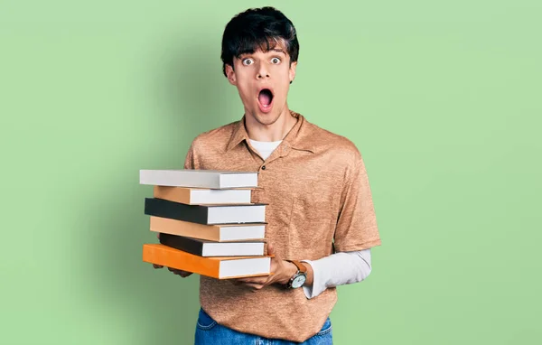 Bonito Jovem Hipster Segurando Uma Pilha Livros Com Medo Chocado — Fotografia de Stock