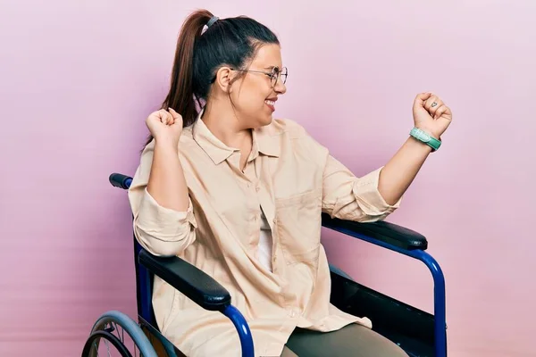 車椅子に座っている若いヒスパニック系の女性が幸せと陽気に踊り 笑顔でカジュアルで自信を持って音楽を聴く — ストック写真