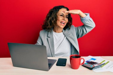 Ofiste çalışan orta yaşlı güzel bir kadın. Bir fincan kahve içiyor. Çok mutlu ve gülümsüyor. arama kavramı. 