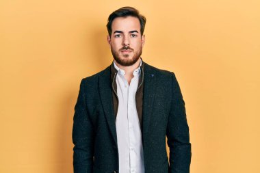 Sakallı, yakışıklı beyaz adam. Yüzünde ciddi bir ifade olan zarif bir iş ceketi giyiyor. Basit ve doğal bir şekilde kameraya bakıyorsun.. 