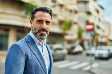 Orta yaşlı işadamı şehirde mutlu mesut dikilirken.
