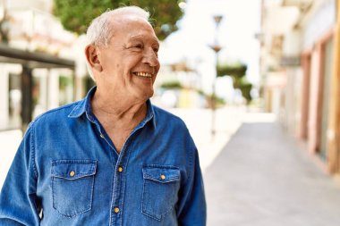 Güneşli bir günde kır saçlı son sınıf öğrencisi dışarıda mutlu mesut dikiliyor. Emeklilik için 70 'lerinde mutlu bir gülümseme.