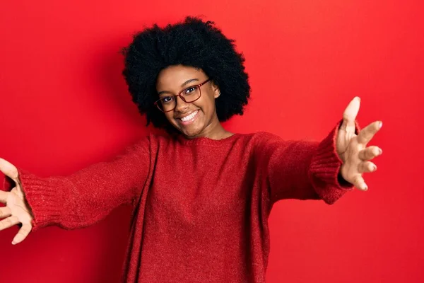カジュアルな服を着た若いアフリカ系アメリカ人女性と 抱擁のために開いた腕で笑顔カメラを見ている眼鏡 幸せを受け入れる陽気な表情 — ストック写真