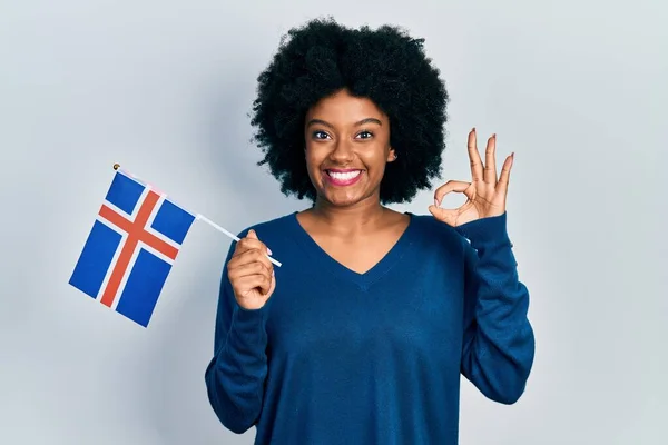若いアフリカ系アメリカ人の女性は 指でOkサインを行うアイスランドのフラグを保持します 笑顔優しいジェスチャー優れたシンボル — ストック写真
