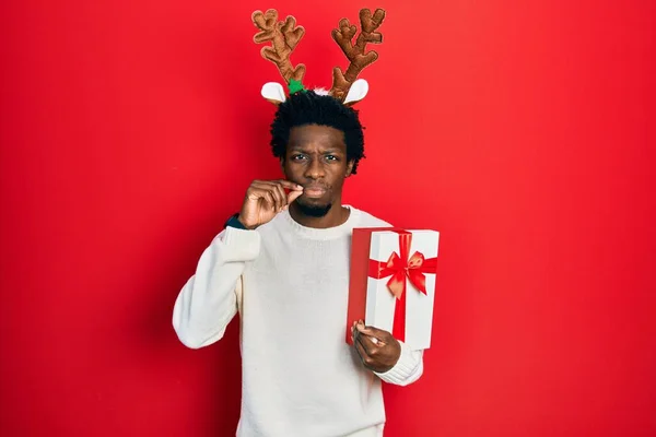 Jovem Afro Americano Vestindo Chapéu Natal Veado Segurando Boca Presente — Fotografia de Stock