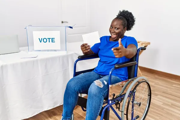 Młoda Afrykanka Siedząca Wózku Inwalidzkim Głosująca Umieszczająca Urnie Wyborczej Palce — Zdjęcie stockowe