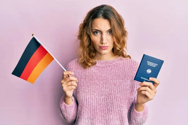 Mujer Caucásica Joven Con Bandera Alemania Pasaporte Escéptico Nervioso Frunciendo —  Fotos de Stock