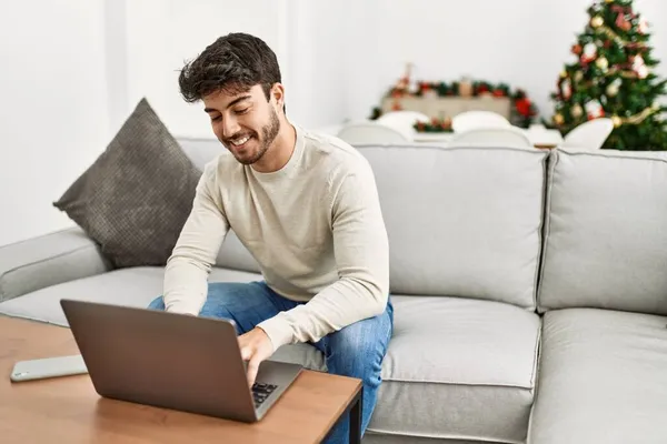 Молодий Іспаномовний Чоловік Посміхається Щасливий Сидячи Дивані Використовуючи Ноутбук Вдома — стокове фото