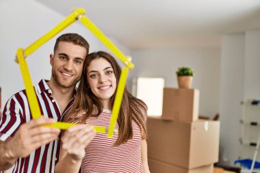 Kafkasyalı genç çift yeni ev projesinde mutlu bir şekilde gülümsüyor..