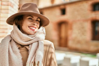 Şık giyinen genç İspanyol kadın şehirde dikiliyor..