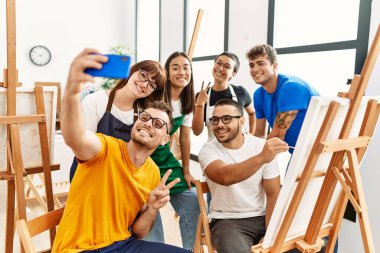 Sanat stüdyosunda mutlu çizimler yapan bir grup insan..