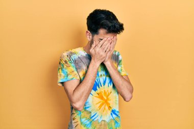 Ağlarken suratını ellerle kapatan, günlük kıyafetler giyen genç İspanyol. depresyon kavramı. 