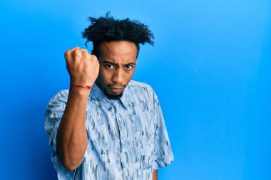 Sakallı genç Afro-Amerikan bir adam. Kızgın ve kızgın. Öfkeyle bağırırken yumruğunu kaldırıyor. öfke ve agresif konsept. 