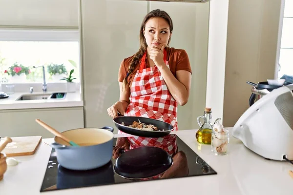Mutfakta Önlük Giymiş Genç Güzel Esmer Bir Kadın Ciddi Bir — Stok fotoğraf