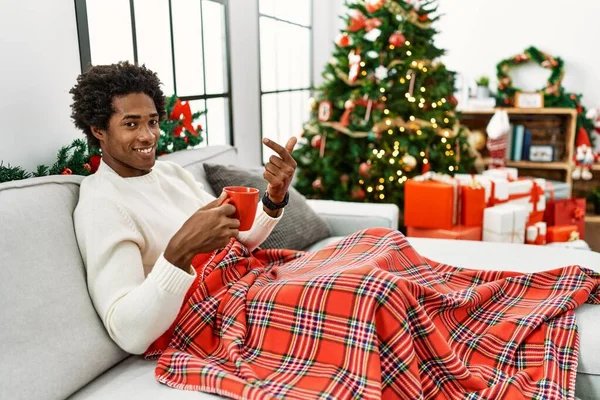 Joven Afroamericano Sentado Sofá Bebiendo Café Por Árbol Navidad Haciendo — Foto de Stock