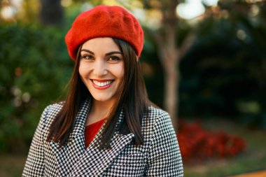 Genç İspanyol kadın gülümseyerek şehirde mutlu mesut dikiliyor..