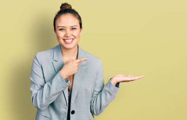 Genç İspanyol kız, mutlu ve havalı bir gülümsemeyle avuç içini göstererek gülümsüyor. diş gösterme. 