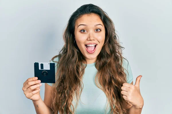Ung Latinamerikansk Flicka Håller Diskett Pekar Tummen Upp Till Sidan — Stockfoto