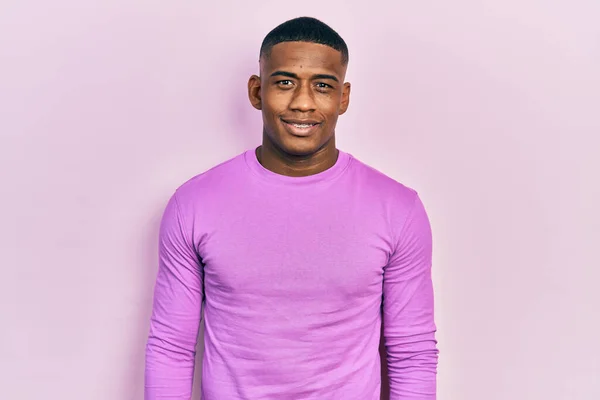 幸せとクールな笑顔でカジュアルなピンクのセーターを着た若い黒人男性 運のいい人 — ストック写真