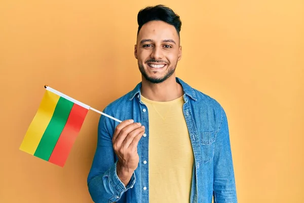 Hombre Árabe Joven Sosteniendo Bandera Lithuania Con Aspecto Positivo Feliz —  Fotos de Stock