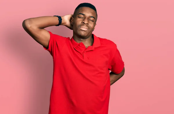 身穿休闲红T恤的年轻非洲裔美国男子颈部疼痛 用手触摸颈部 肌肉疼痛 — 图库照片