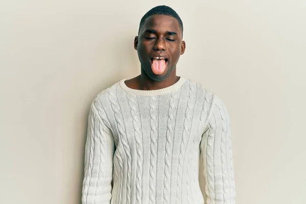身穿休闲服的年轻的非洲裔美国人 带着滑稽的表情 高兴地伸出舌头 情感概念 — 图库照片