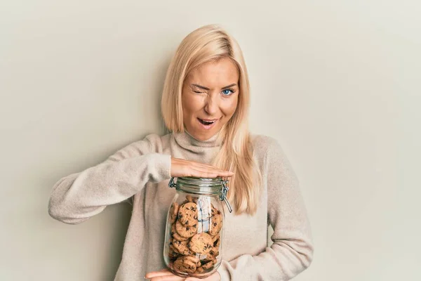 Jovem Loira Segurando Jar Com Chips Chocolate Biscoitos Piscando Olhando — Fotografia de Stock