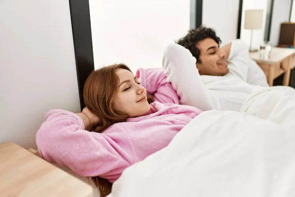 Молода Пара Посміхається Щаслива Розслаблена Руками Голові Лежить Ліжку Спальні — стокове фото