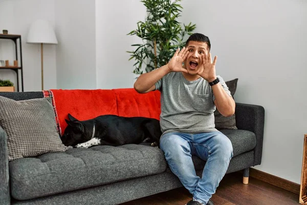 Jovem Latino Homem Cão Sentado Sofá Casa Sorrindo Alegre Jogando — Fotografia de Stock