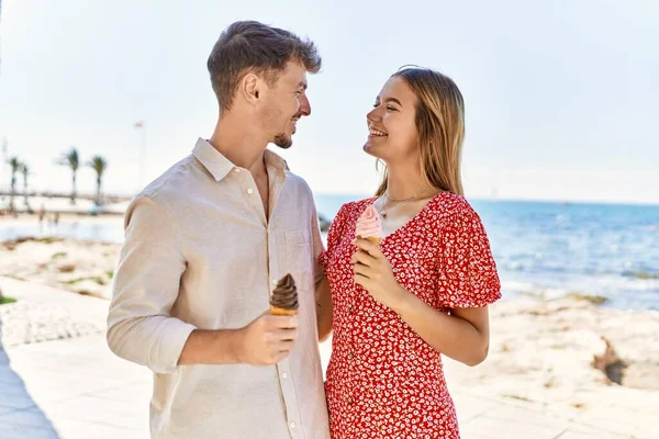 스페인 남녀가 휴가중에 해변에서 아이스크림을 먹으며 미소를 — 스톡 사진