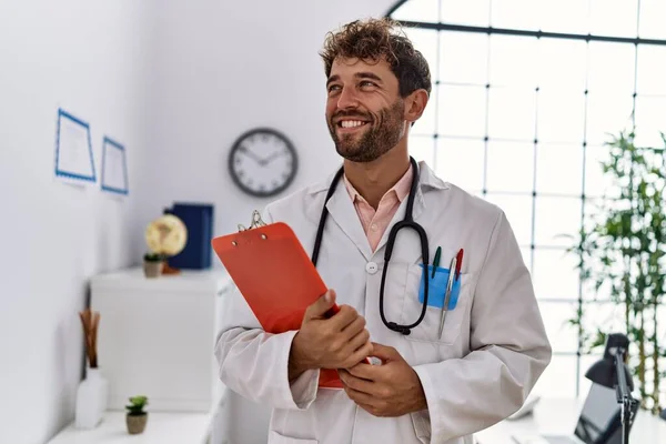 Jonge Spaanse Man Doktersuniform Met Klembord Kliniek — Stockfoto