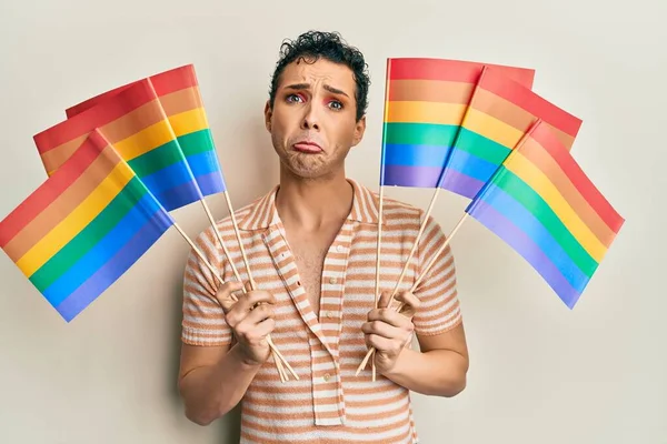 Hombre Guapo Usando Maquillaje Sosteniendo Banderas Arco Iris Lgbtq Deprimido —  Fotos de Stock