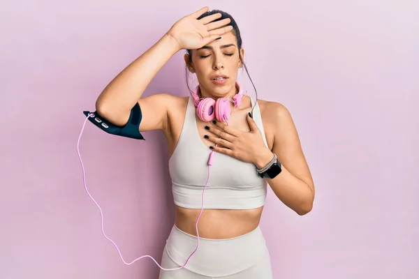 Ung Latinamerikansk Kvinna Gympakläder Och Med Hörlurar Som Vidrör Pannan — Stockfoto