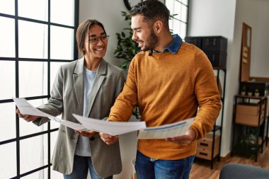 Ofiste bekleyen iki işadamı mutlu bir şekilde evrak okuyorlar..