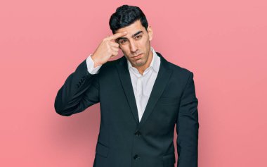 İş kıyafetleri giymiş yakışıklı İspanyol adam alnında sivilce çıkmasından mutsuz olduğunu gösteriyor, siyah noktalı çirkin bir enfeksiyon. sivilce ve deri problemi 