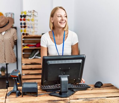 Giyim mağazasında çalışan kendine güvenen genç sarışın kadın.