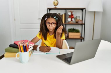 Young african american girl doing homework at home doing italian gesture with hand and fingers confident expression 