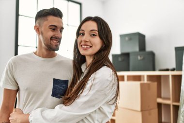 Genç İspanyol çift mutlu bir şekilde gülümsüyor ve yeni evlerinde birbirlerine sarılıyorlar..