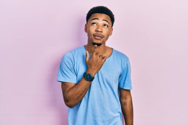 Genç Afro-Amerikalı bir adam günlük mavi tişört giyiyordu. Düşünceleri kuşkuya yoğunlaşmıştı. Parmakları çenesinde ve yukarı bakıyordu. 