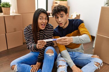 Genç Latin çift yeni evlerinde yerde otururken hamilelik testi yaparken şaşırdılar..