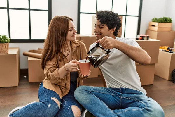 Młoda Para Uśmiechnięta Szczęśliwa Pijąc Kawę Nowym Domu — Zdjęcie stockowe