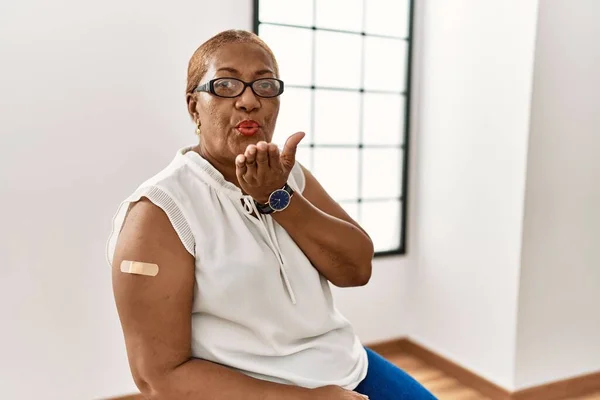 Starší Hispánka Dostává Vakcínu Ukazující Ruku Náplastí Dívá Kamery Fouká — Stock fotografie