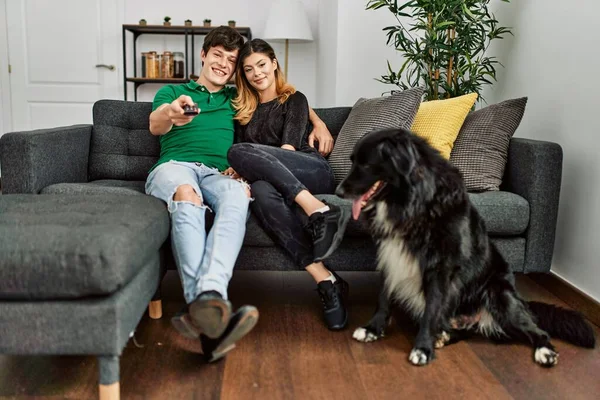 Joven Caucásico Pareja Viendo Sentado Sofá Con Perro Casa —  Fotos de Stock
