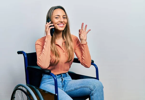 Beautiful Hispanic Woman Sitting Wheelchair Talking Phone Doing Sign Fingers — Stock Photo, Image