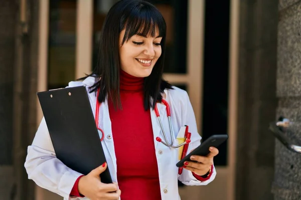 Mladá Brunetka Žena Nosí Lékařskou Uniformu Pomocí Smartphone Vchodu Domu — Stock fotografie