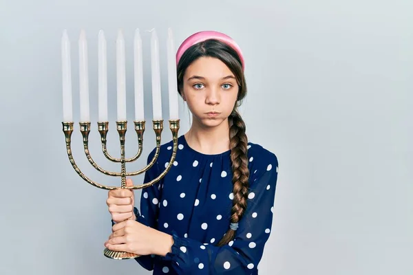 Menina Morena Jovem Segurando Menorah Hanukkah Vela Judaica Soprando Bochechas — Fotografia de Stock