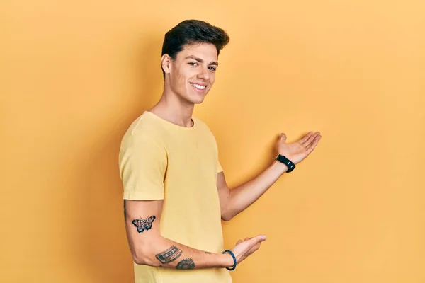 Joven Hombre Hispano Con Camiseta Amarilla Casual Invitando Entrar Sonriente — Foto de Stock
